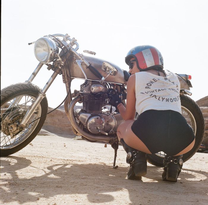 A playful frame from Girls on a motorcycle — online in Muscat